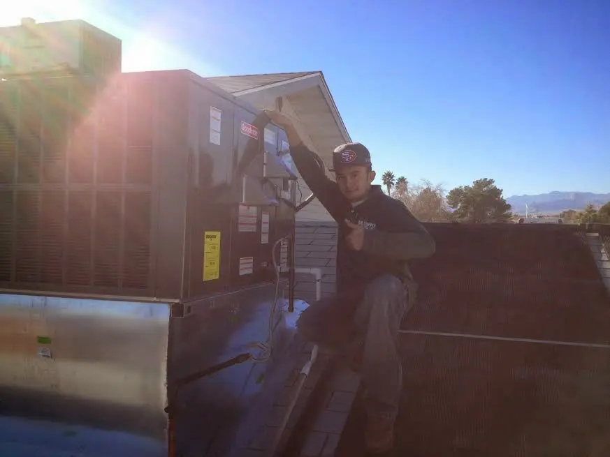 HVAC technician performing HVAC Inspection on a rooftop unit in Pennfield